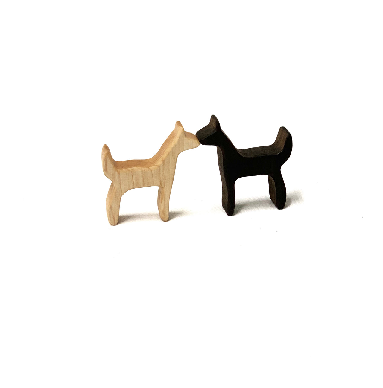 Two small handcrafted wooden animal figurines in natural and dark wood tones on white background