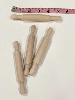 Natural wooden rolling pins for sensory bins with smooth handles and a pink measuring tape on white background