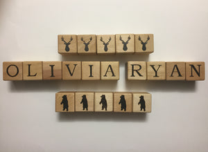 Natural wooden 1.5 inch custom blocks with black engraved letters spelling OLIVIA RYAN and animal silhouettes on white background