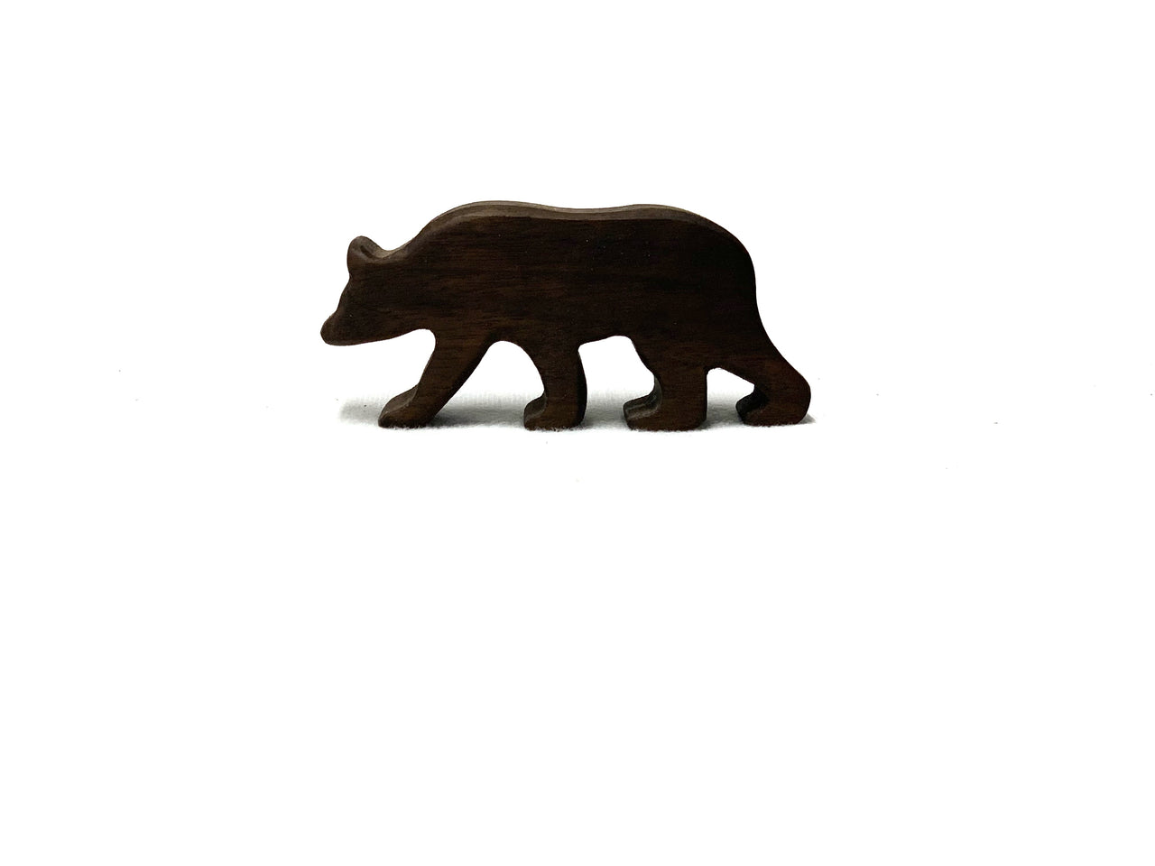 Small dark brown wooden bear figurine toy with smooth edges on white background