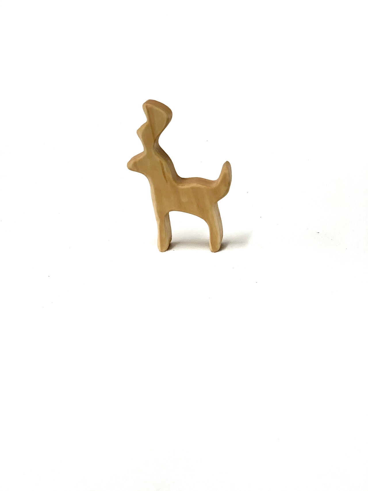 Natural wooden buck deer animal toy figurine with simple shape standing on white background