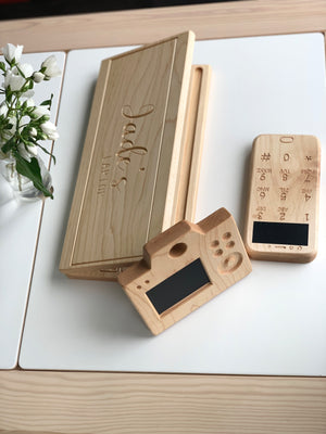Wooden toy laptop and phone with chalkboard screens and engraved personalized name on natural wood background