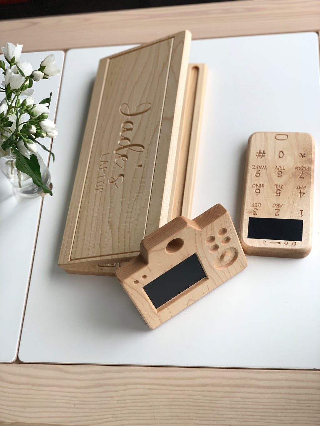 Wooden toy laptop and phone with chalkboard screens and engraved personalized name on natural wood background