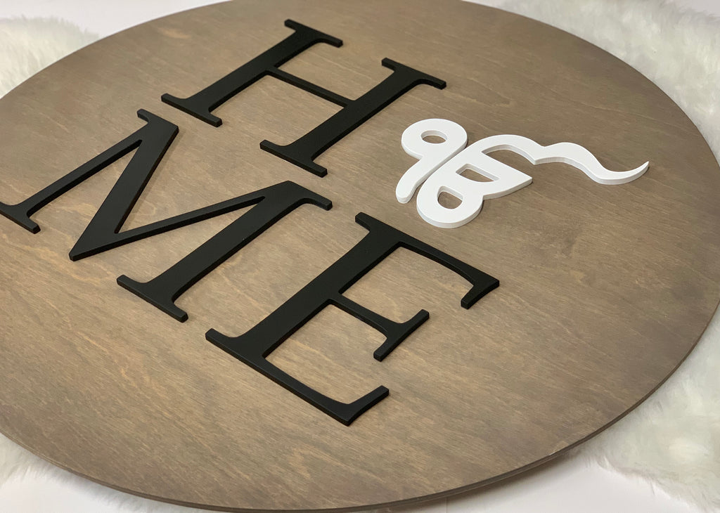 3D round wooden name sign with black letters and white decorative symbol on natural wood background