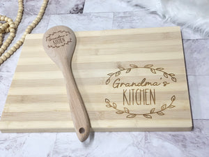 Personalized bamboo cutting board and wooden spoon engraved with Grandma’s Kitchen and decorative leaf design