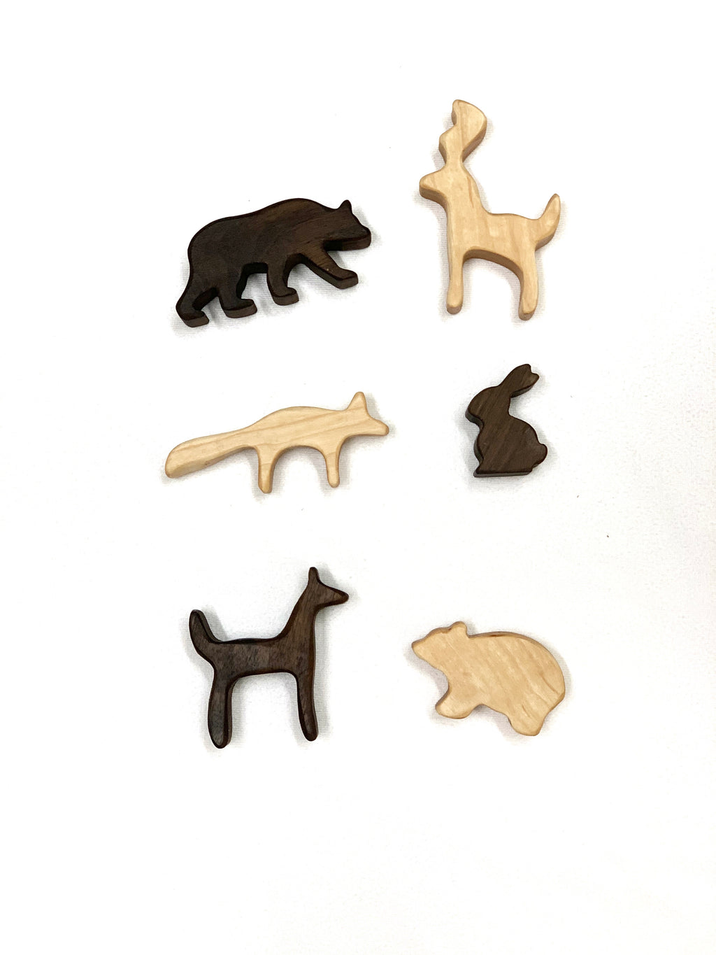 Small wooden woodland animal toy figurines in light and dark wood on white background