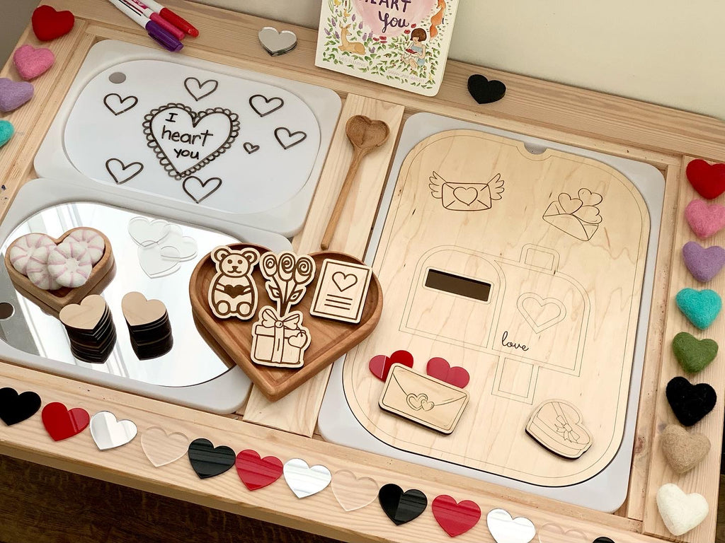 Set of 7 laser-cut heart acrylic shapes with wooden heart tray, wooden spoon, and love-themed sensory play materials on wooden table