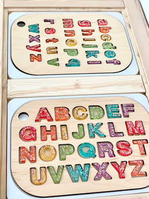 Wooden Flisat table top inserts with colorful resin uppercase and lowercase alphabet letter sets on light wood surface
