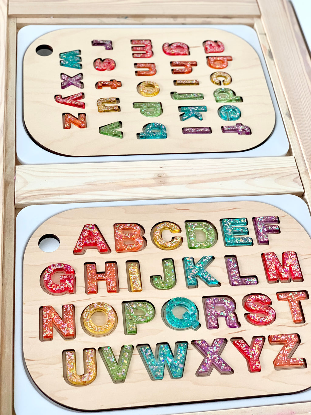 Wooden Flisat table top inserts with colorful resin uppercase and lowercase alphabet letter sets on light wood surface