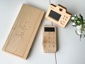Personalized wooden laptop toy computer with chalkboard screen and wooden toy phone and camera on white table