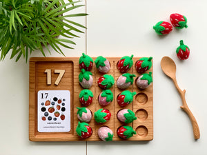 Wooden 20 frame sensory tray with felt strawberries, wooden number tiles showing 17, and carved wooden spoon on white surface