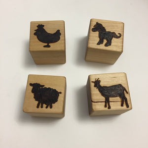 Natural 1.5 inch wooden blocks with engraved black animal silhouettes of chicken, dog, sheep, and goat on white background