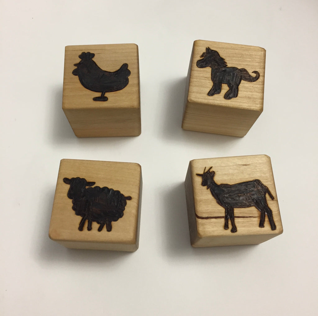 Natural 1.5 inch wooden blocks with engraved black animal silhouettes of chicken, dog, sheep, and goat on white background