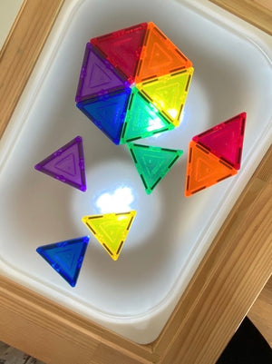 Small frosted acrylic Flisat table top insert with colorful translucent magnetic triangles on wooden frame background