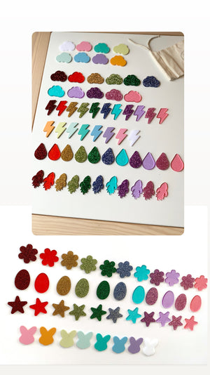 Colorful laser cut acrylic shapes including clouds, lightning bolts, raindrops, and flowers arranged on white surface