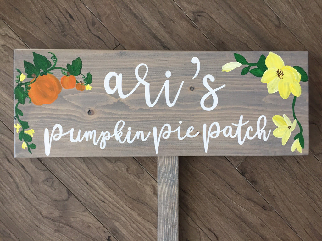 Large custom wooden garden sign with white cursive letters and painted pumpkins and yellow flowers on gray wood background