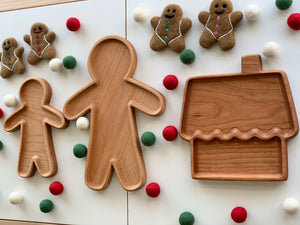 Set of natural wooden sensory trays shaped like gingerbread people and a house surrounded by colorful felt balls