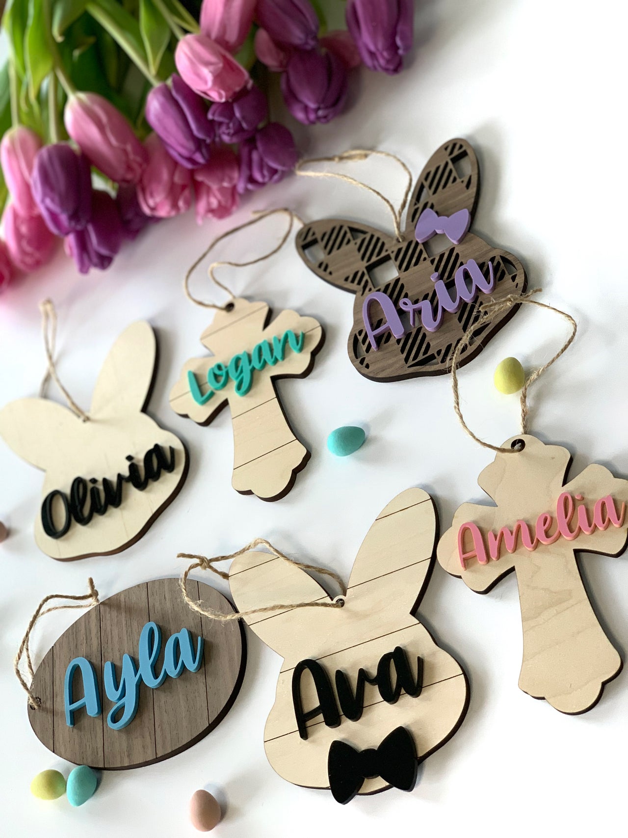 Custom wooden Easter basket name tags in bunny and cross shapes with colorful acrylic names and string hangers