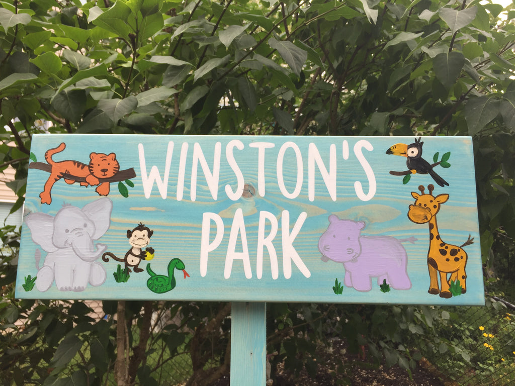 Large personalized wooden garden sign with white letters and colorful cartoon jungle animals on blue wood background