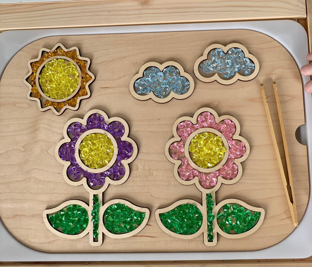 Wooden fillable flower and cloud scene insert with yellow, purple, pink, and blue gel beads and natural wood tweezers