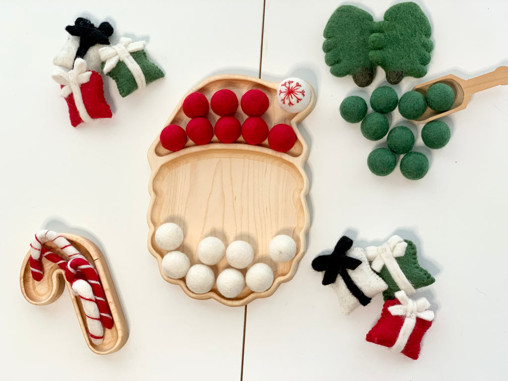 Wooden Candy Cane Plate Sensory Tray with red and white felt balls and small felt gift decorations on white surface