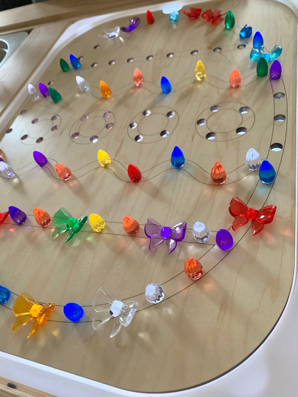 Light wood Easter egg-shaped Flisat insert with colorful translucent pegs arranged in patterns on Trofast bin topper