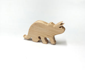 Natural wooden triceratops dinosaur toy figurine with smooth edges on white background for imaginative play