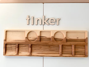 Extra large wooden tinker tray plate with multiple shaped compartments on white surface and wooden letters spelling tinker above