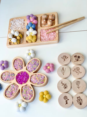 Natural wooden rectangle plate tinker tray with colorful felt balls, wooden tokens, and wooden flower-shaped tray with sensory fillers