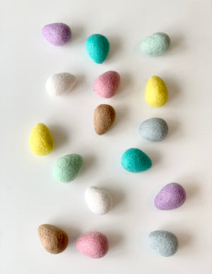 Assorted colorful felt Easter eggs made from pure wool arranged on white background