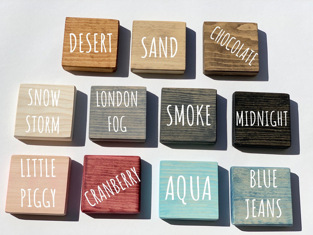 Natural wooden 2-inch blocks in various colors with white engraved letters displaying color names on white background