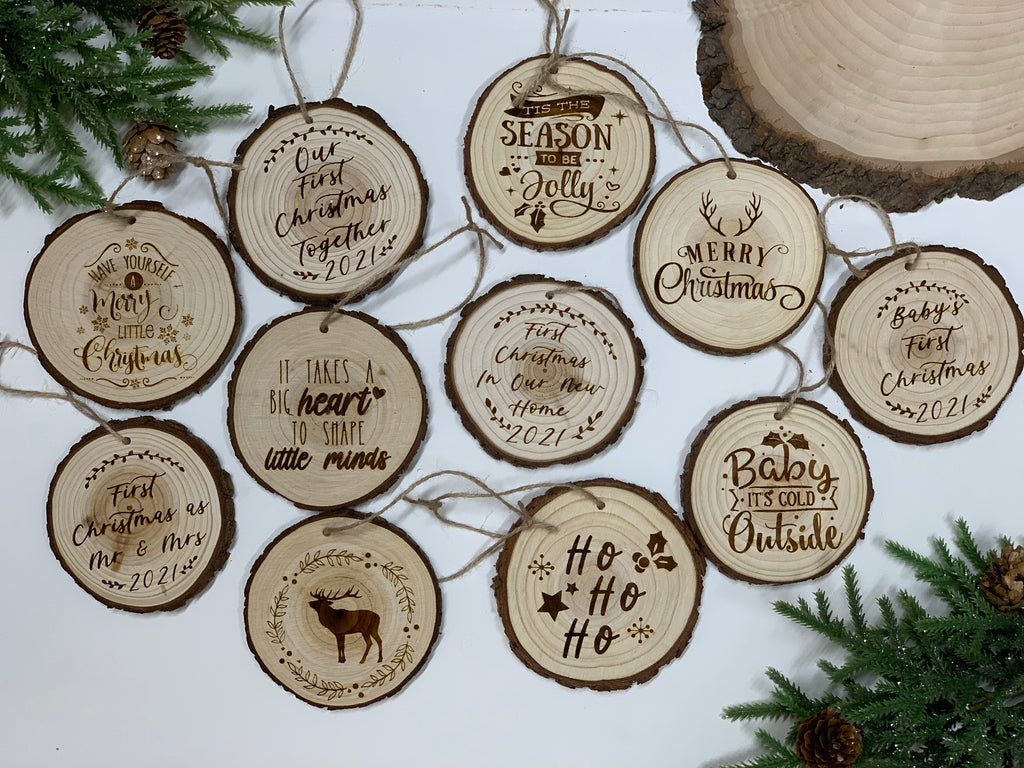Set of rustic round wood burned Christmas ornaments with various holiday and baby’s first Christmas phrases and designs