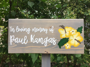 Large personalized wooden garden memorial sign with white cursive lettering and yellow floral illustration on gray wood background