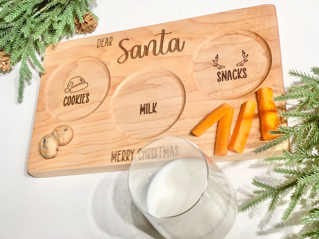 Personalized wooden Santa snack plate with engraved cookies, milk, and reindeer snacks sections on natural wood background