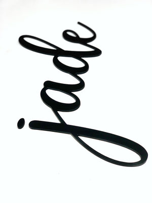 Black custom word cutout in cursive script spelling "jade" on white background with smooth edges