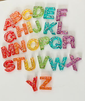 Rainbow glitter resin uppercase alphabet letters A to Z arranged on white background