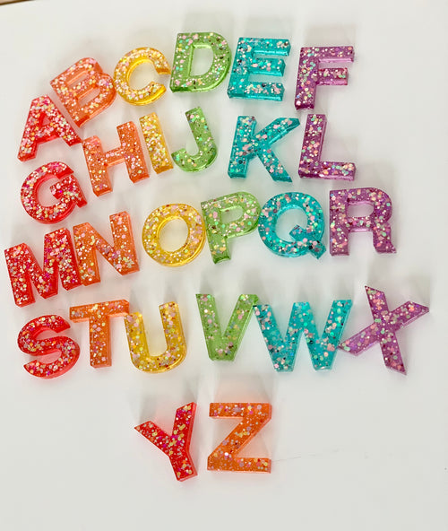 Rainbow glitter resin uppercase alphabet letters A to Z arranged on white background