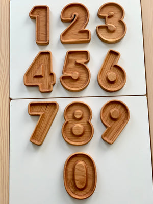 Natural wooden number plate sensory trays shaped as digits 1 through 9 and 0 on white background