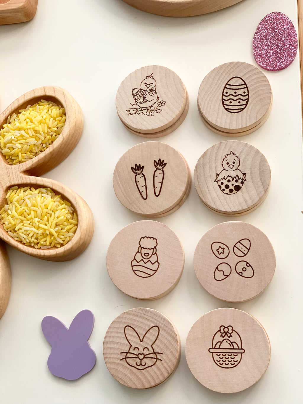 Natural wooden memory game discs with Easter-themed engraved images including chick, egg, carrot, bunny, and basket on white surface