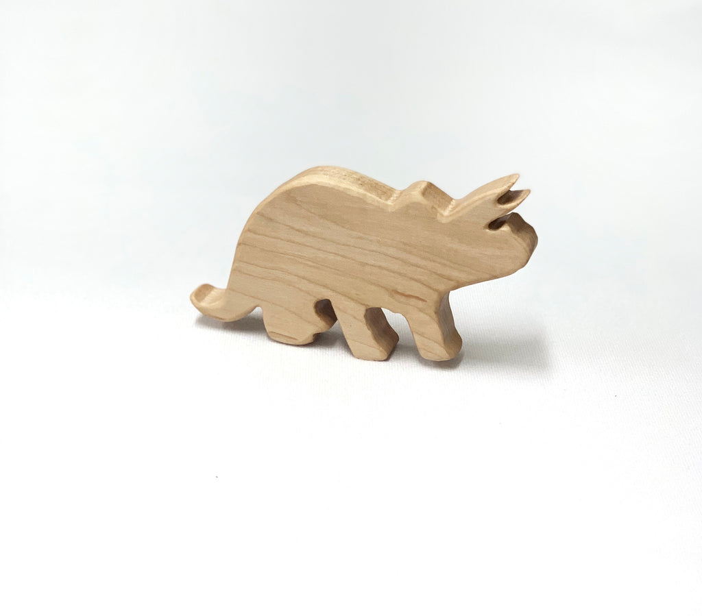 Small natural wooden Triceratops dinosaur toy figurine with smooth edges on white background