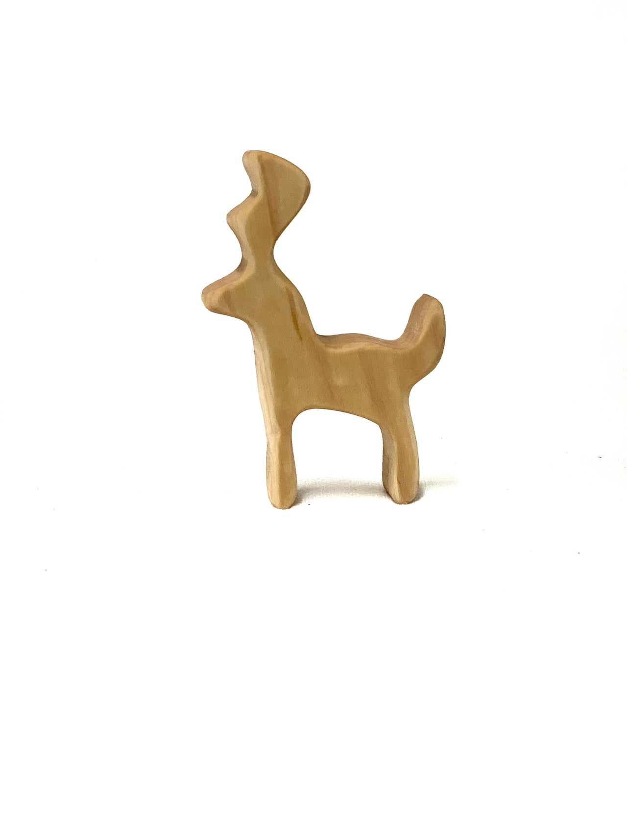 Small natural wood toy figurine shaped like a simplified buck deer with curved antlers on white background