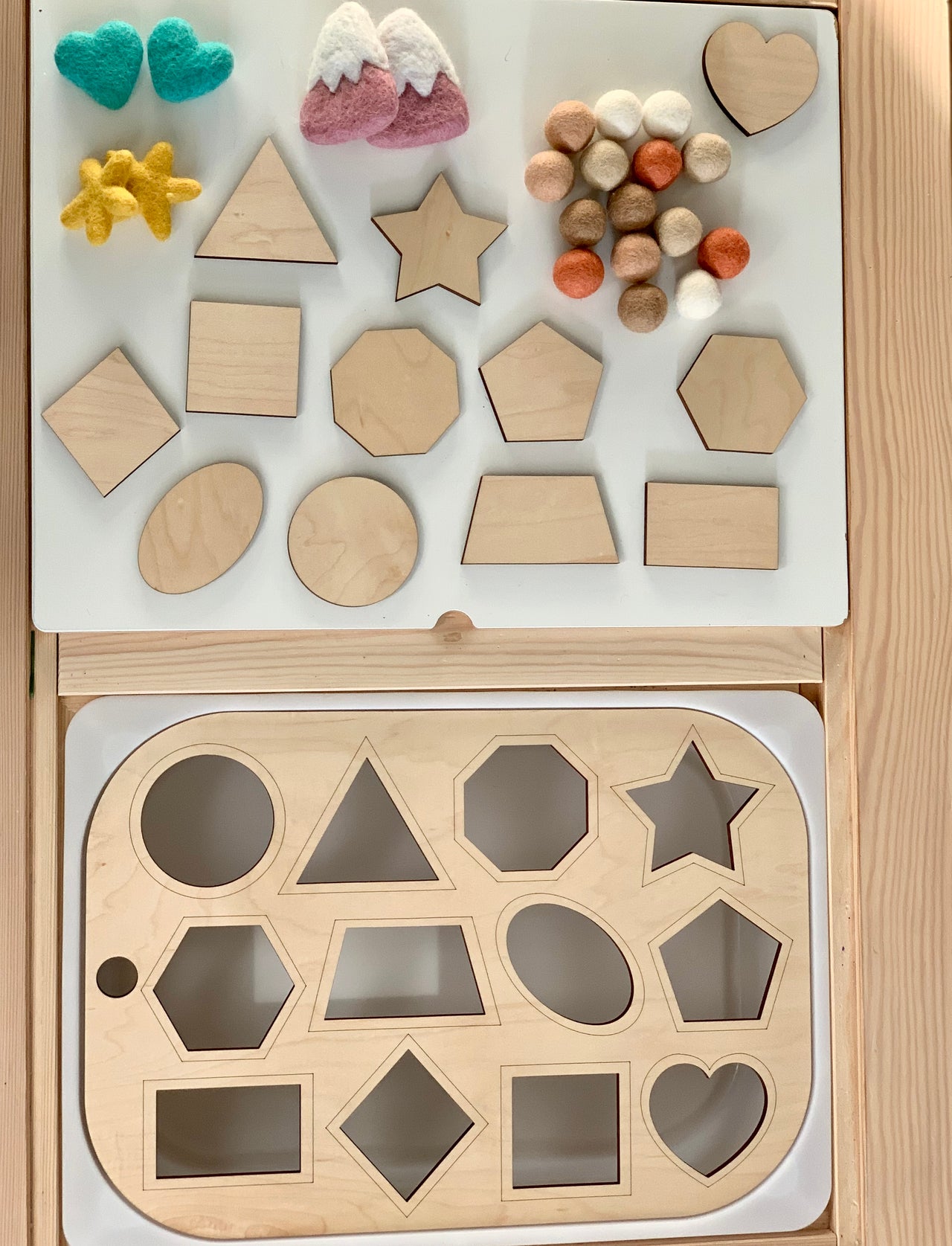 Wooden shape sorter Flisat table top insert with geometric shapes and colorful felt balls on wooden surface